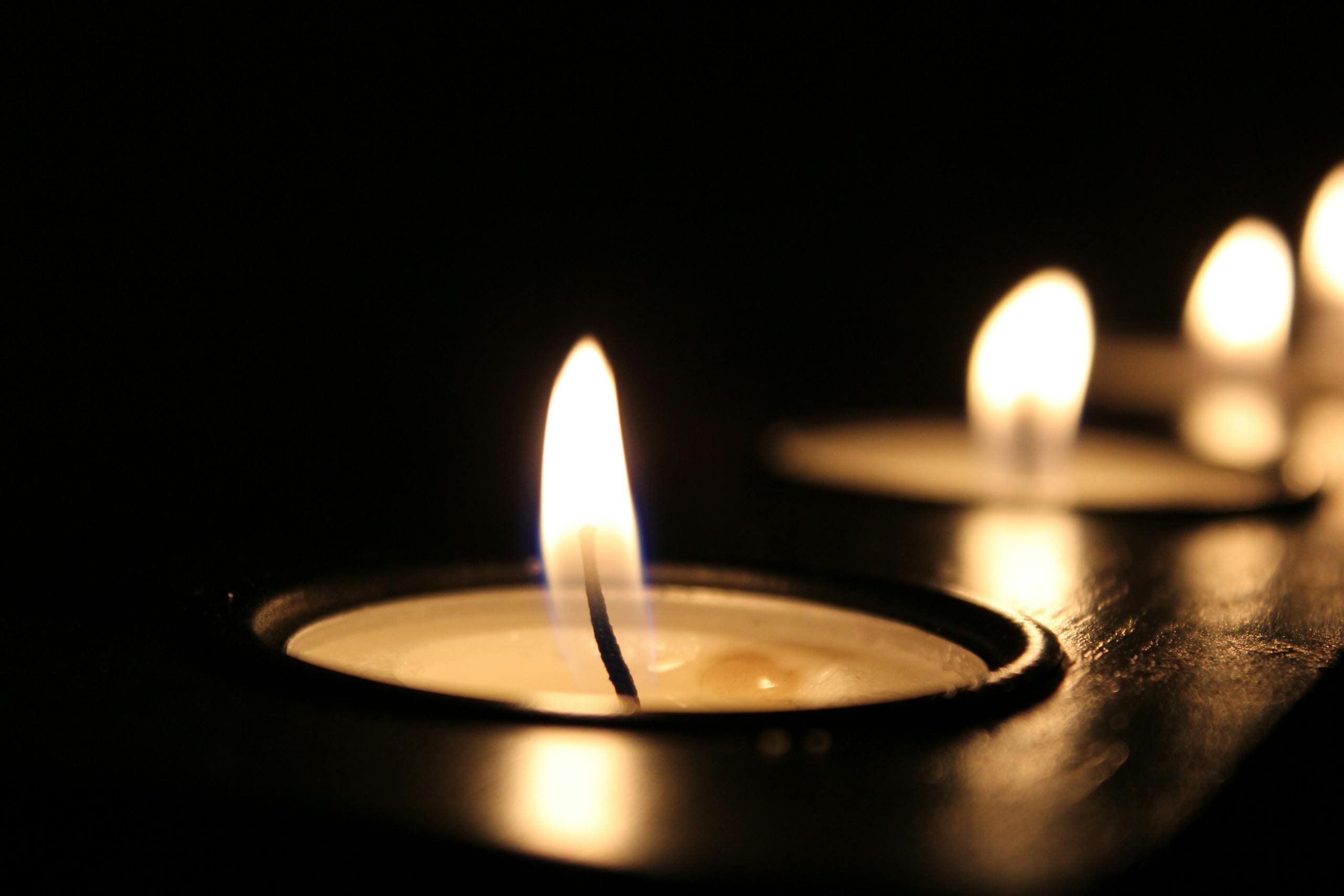 Close-up of glowing candle flames in the dark, creating a warm ambiance.